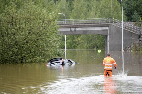 Работници, борещи се с бедствията, се опитват да извадят наводнена кола след поройните дъждове в Швеция. Снимка: БГНЕС