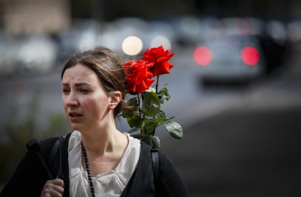 Жена носи цветя в раницата си по улиците на Москва. Снимка: БГНЕС