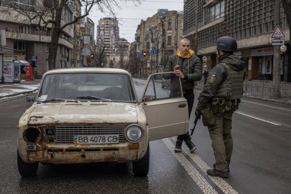 Член на националната гвардия на Украйна спира за проверка стара кола по улиците на Киев. Снимка: БГНЕС